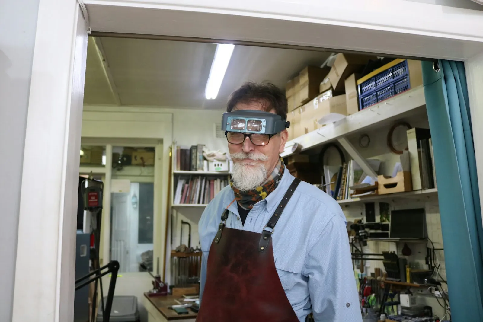 A maker at work in a small, tool-lined studio